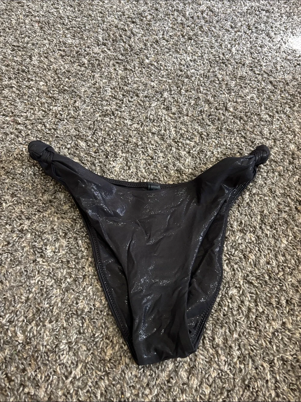SKIMS Liquid Shine Swim Knotted Cheeky Tanga Bottom in the color Onyx M beach